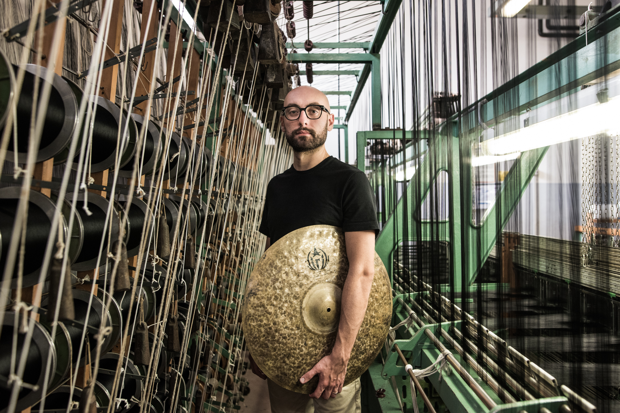 Alessandro Rossi con un piatto in una sala di corde musicali